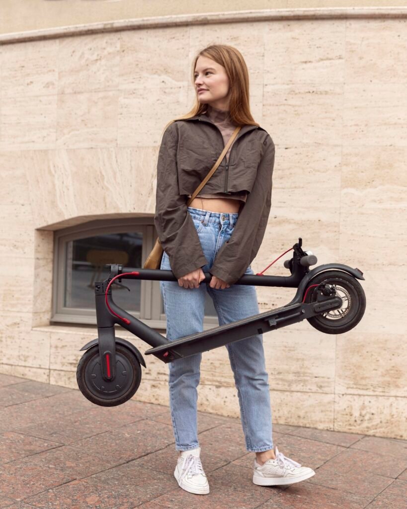 front view woman outdoors holding electric scooter 1